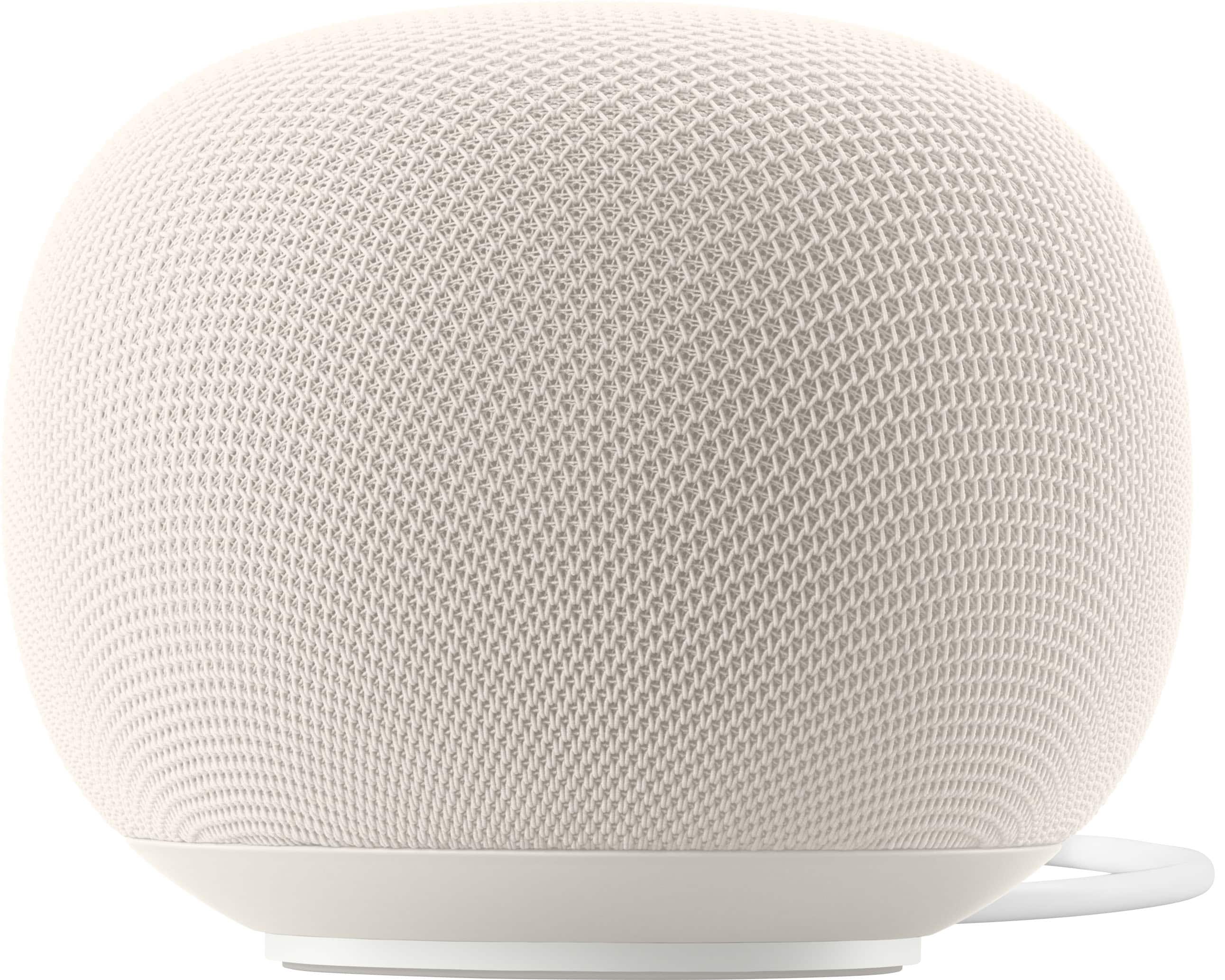 Google Home smart speaker on a modern coffee table, showing Porcelain finish and 360-degree sound ports